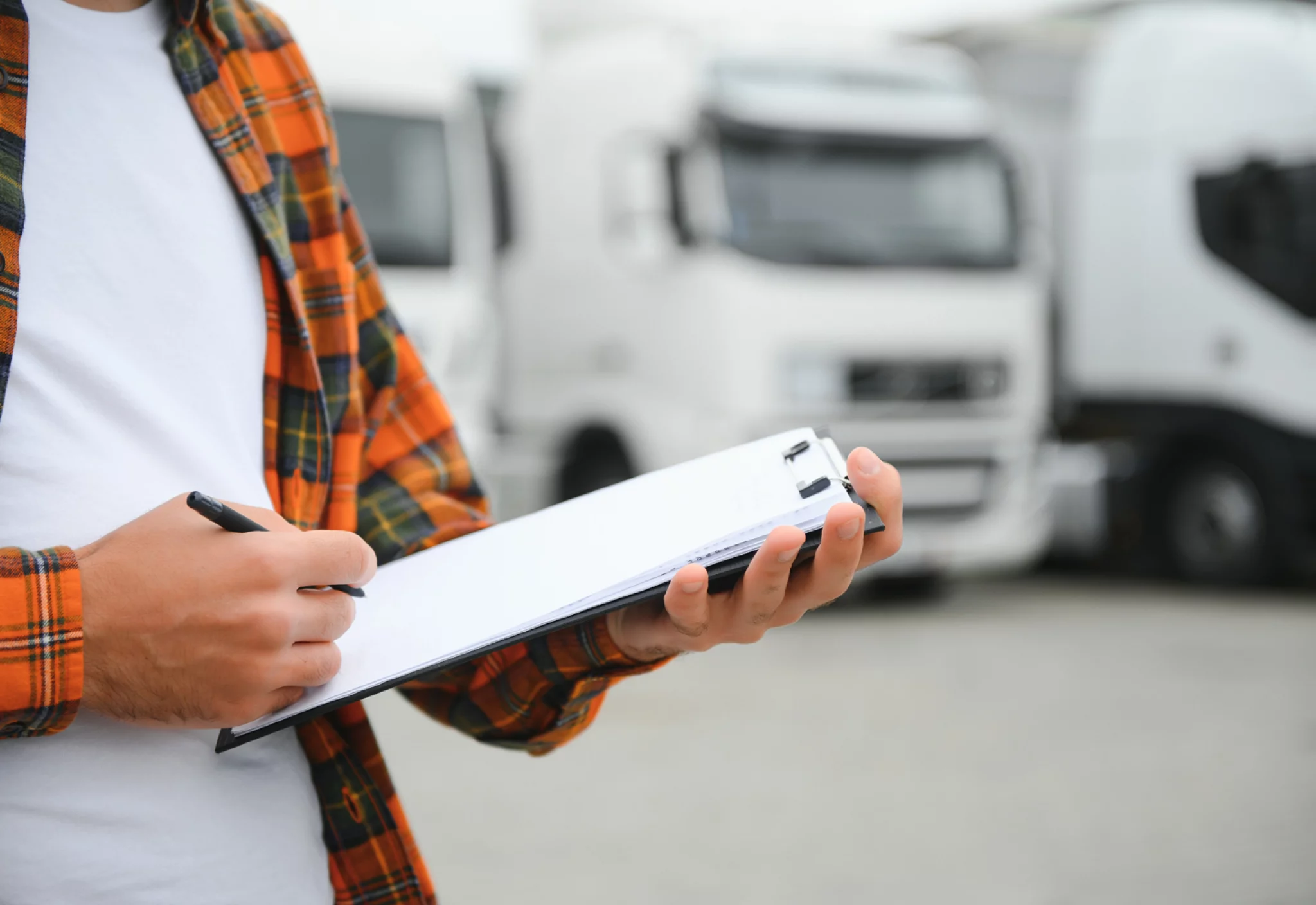 male-driver-with-clipboard-near-big-truck-outdoors.jpg