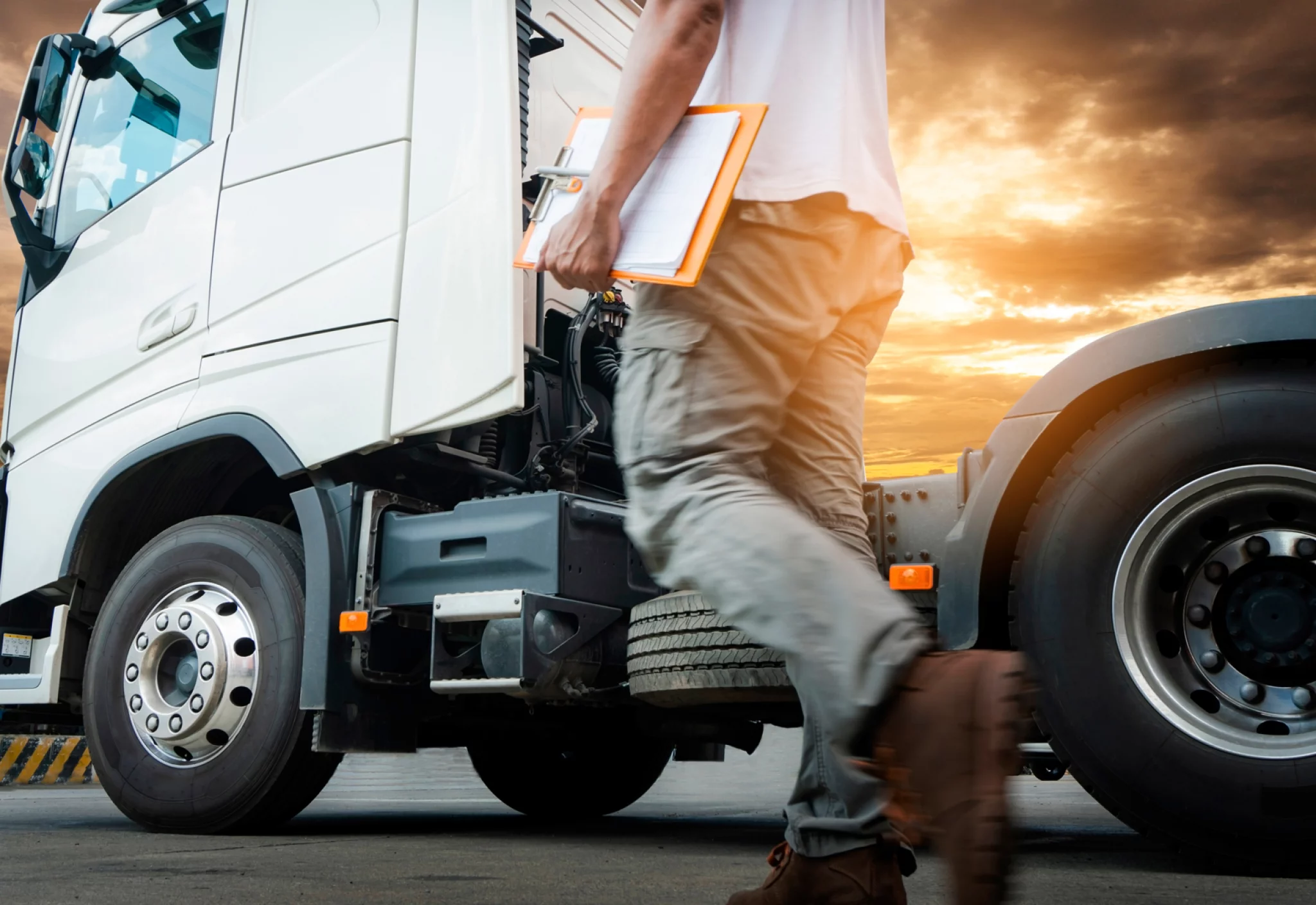 truck-driver-walking-holding-clipboard-is-checking-safety-around-semi-truck.jpg